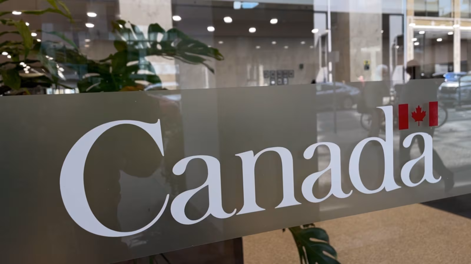 Enseigne vitrée portant le mot-symbole « Canada » dans le hall d'un immeuble de bureaux.
